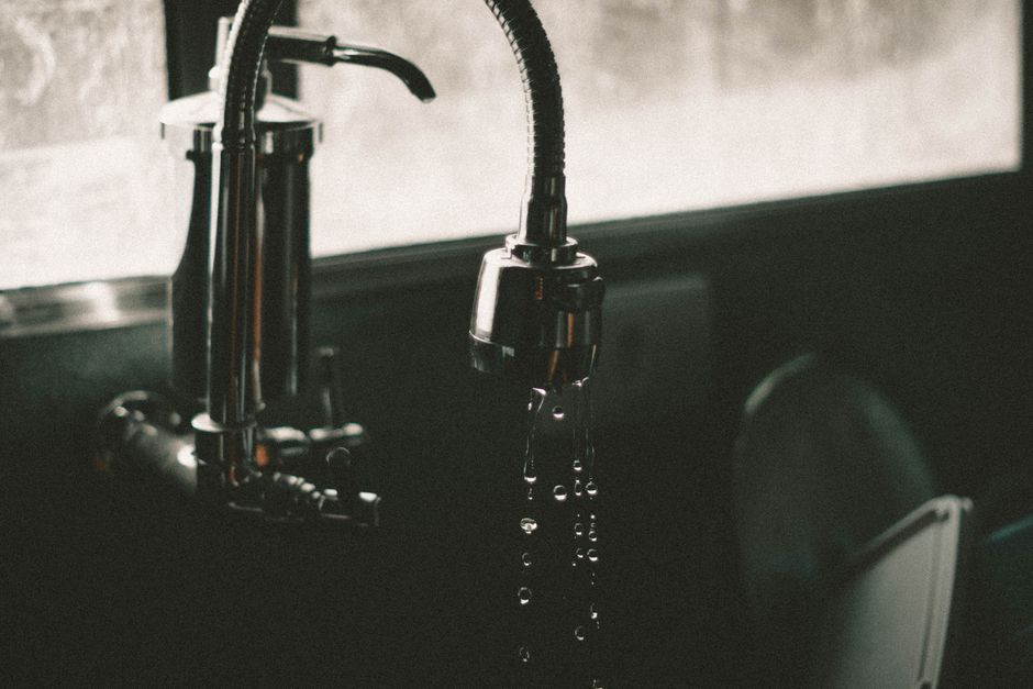 Close-up of a homeowner checking a kitchen sink drain in a Dorset cottage